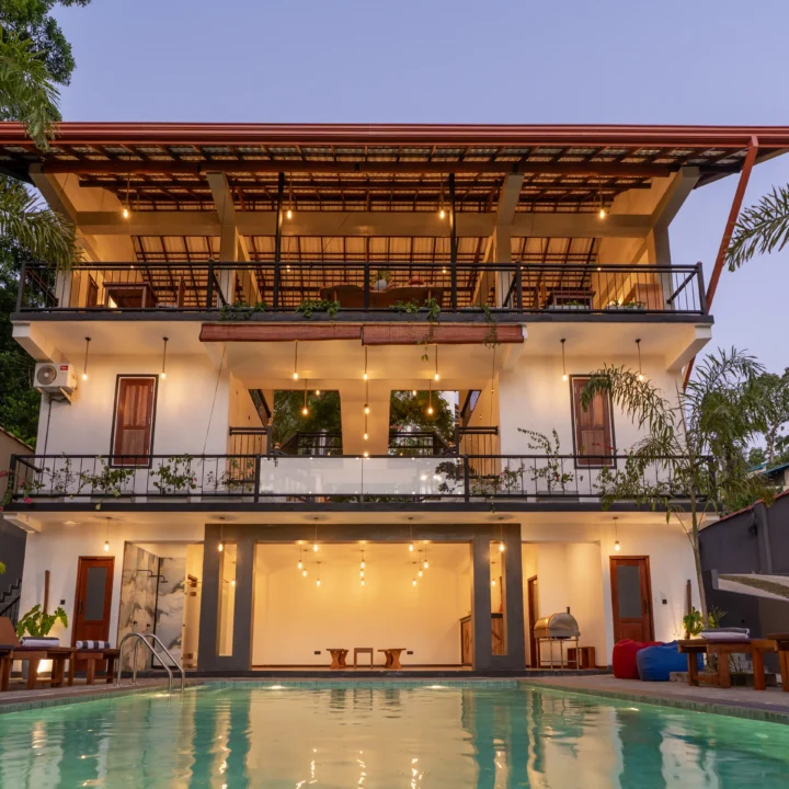 Full villa exterior with swimming pool and upper-floor dining area at sunset – Arice Eco Villa