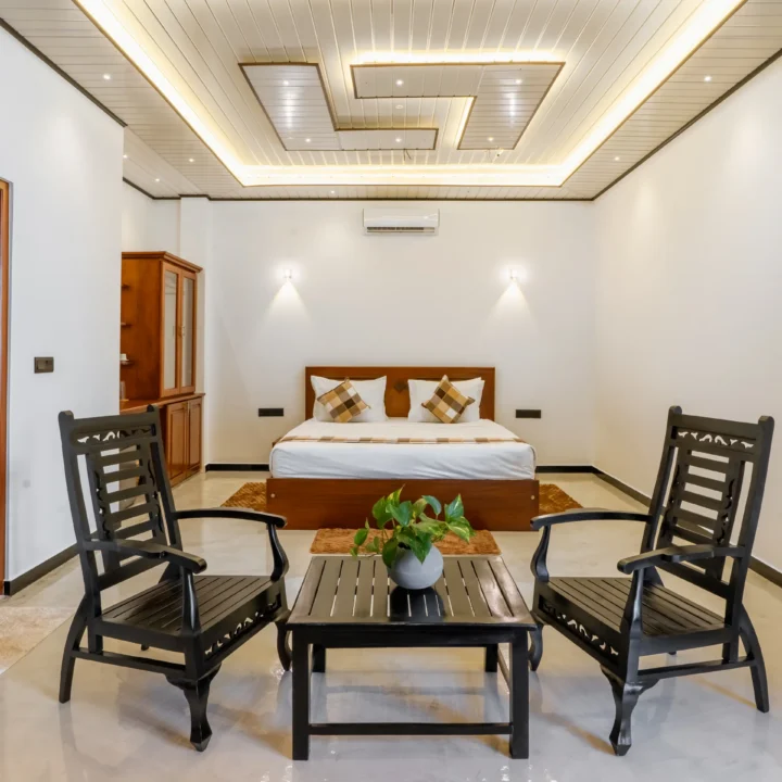 Luxury King Room at Arice Unawatuna with seating area, modern ceiling design, and wooden furnishings.