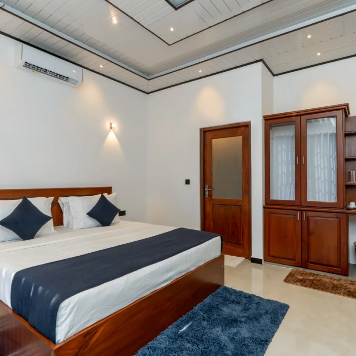 Spacious Deluxe Double Room at Arice Unawatuna featuring wooden furniture and cozy bedding.