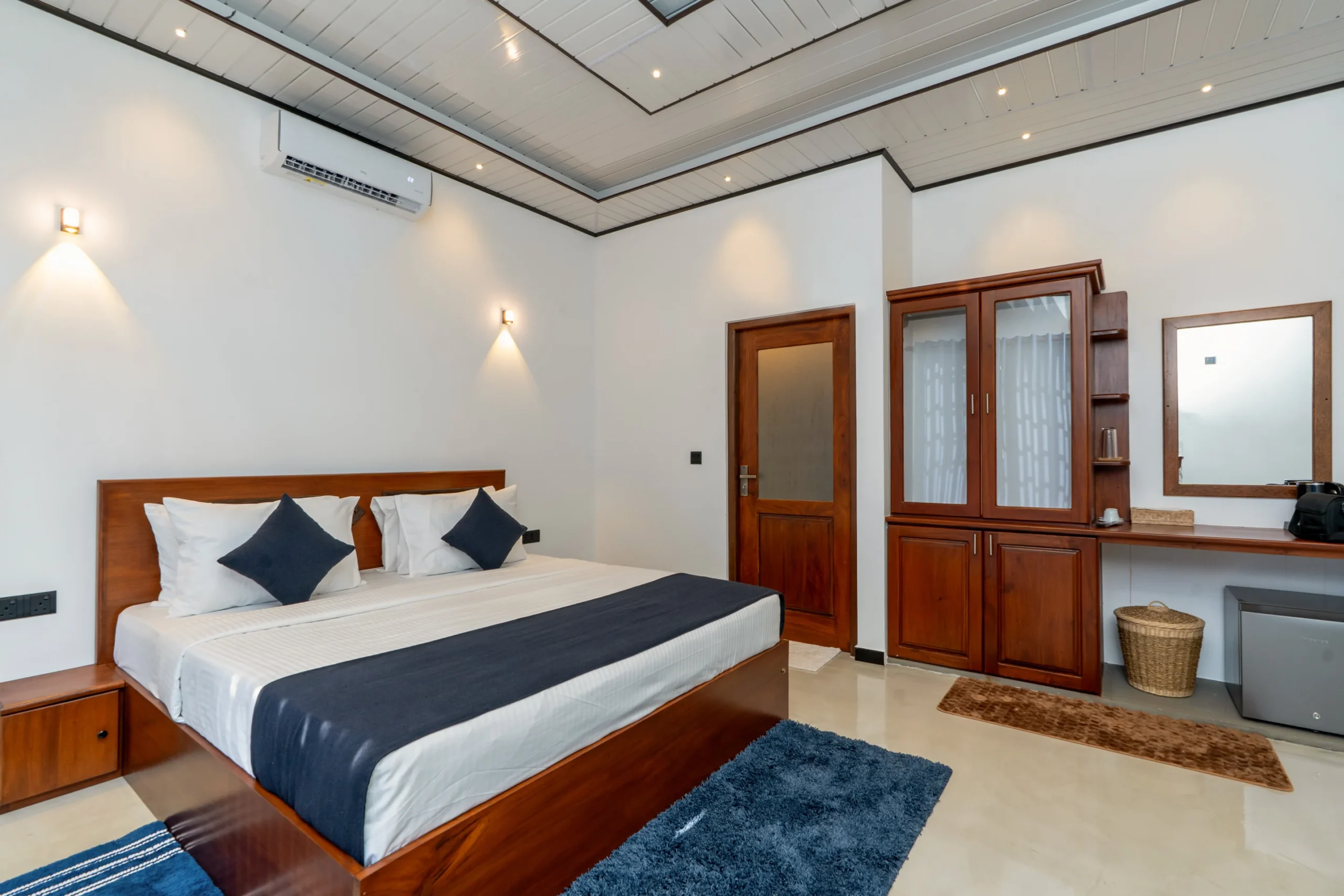 Spacious Deluxe Double Room at Arice Unawatuna featuring wooden furniture and cozy bedding.