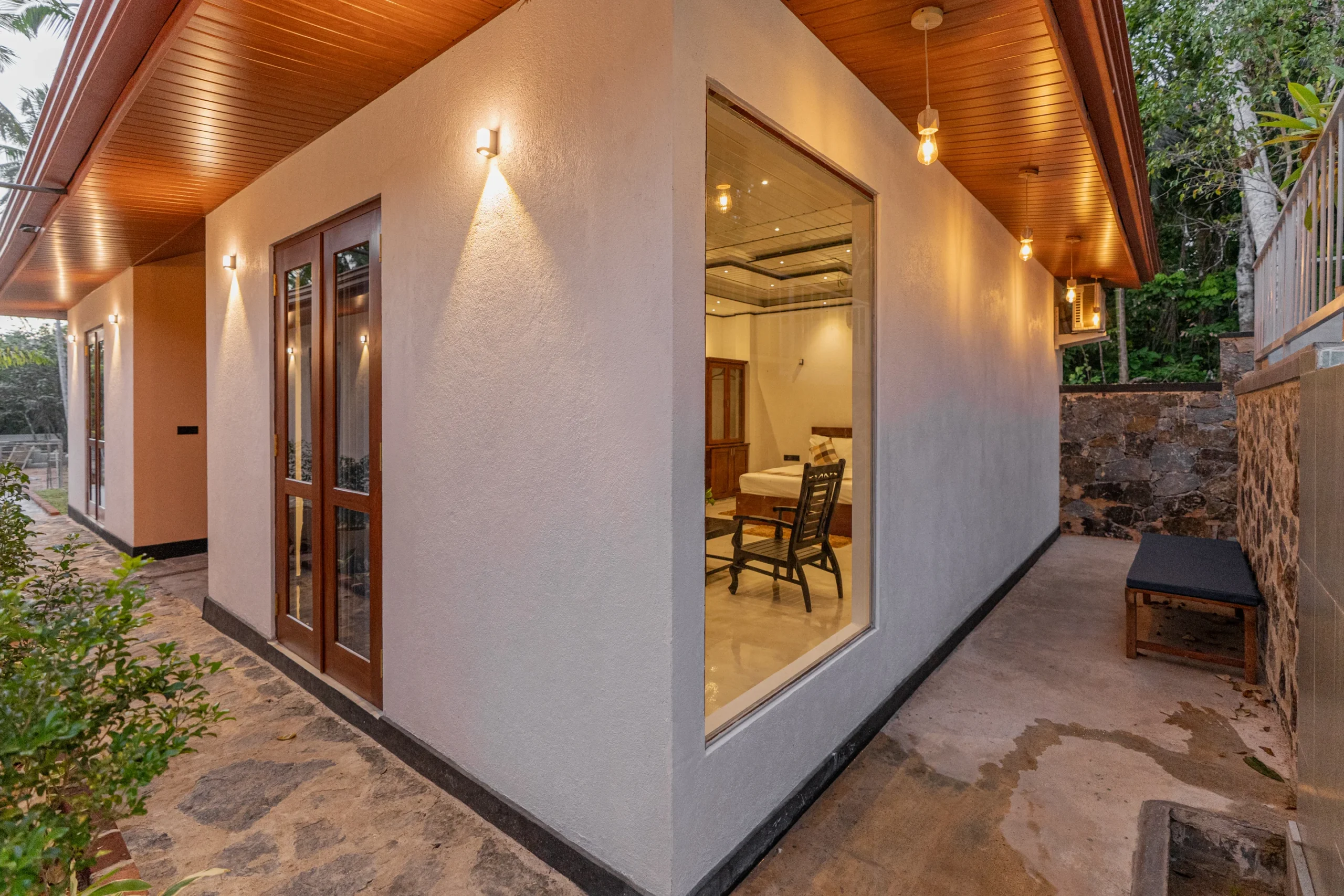 Exterior night view of villa unit with warm lighting and walkway at Arice Eco Villa