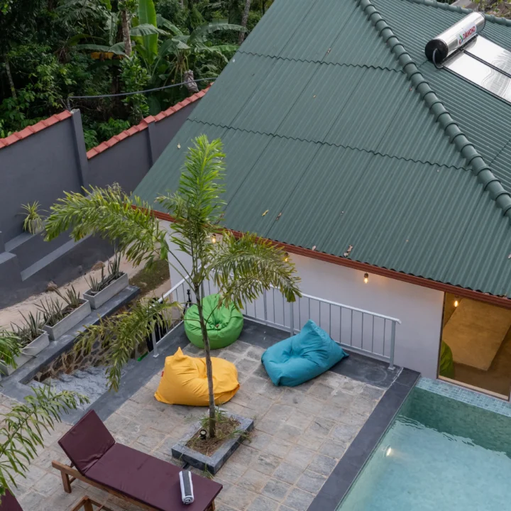 Relaxing poolside area with sun loungers and colorful beanbags at Arice Eco Villa