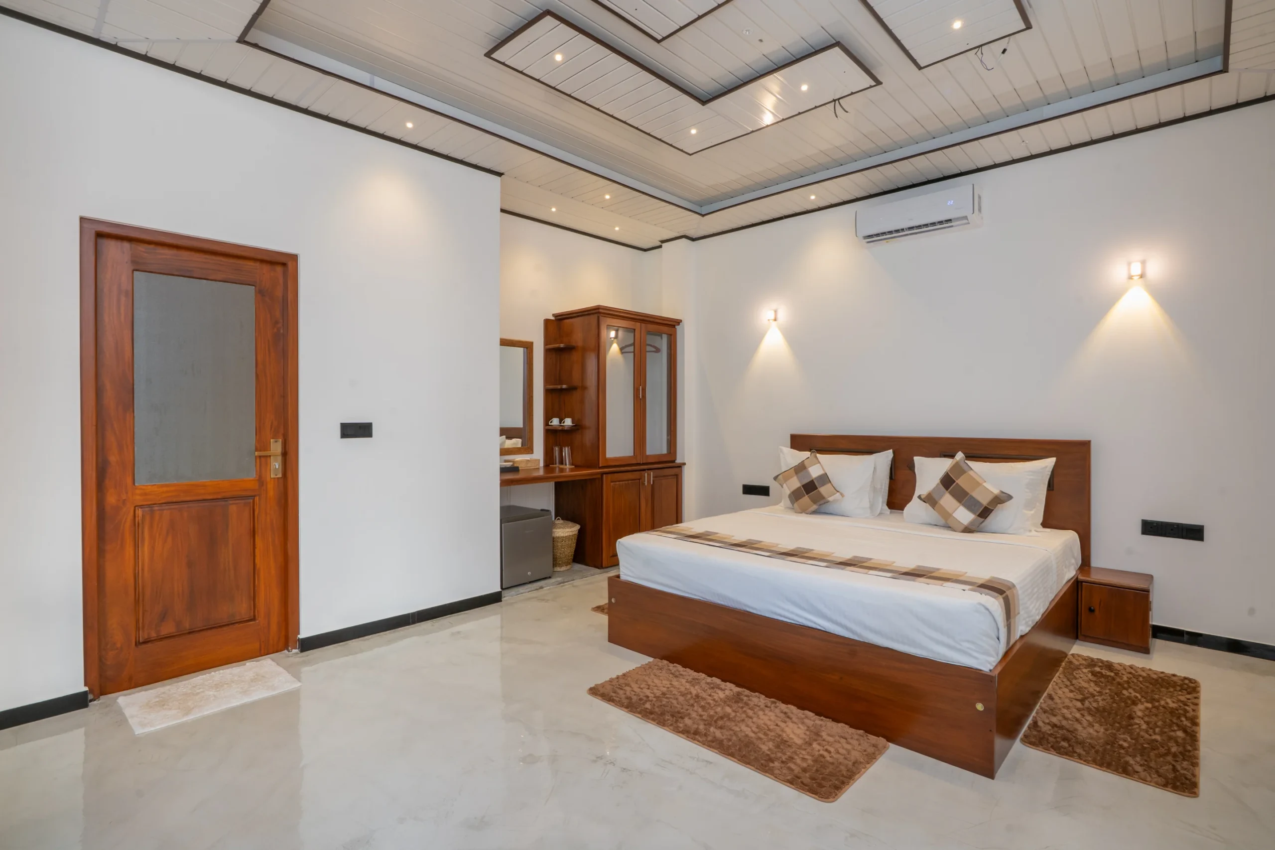 Deluxe room with checkered pillows and wooden furniture at Arice Eco Villa