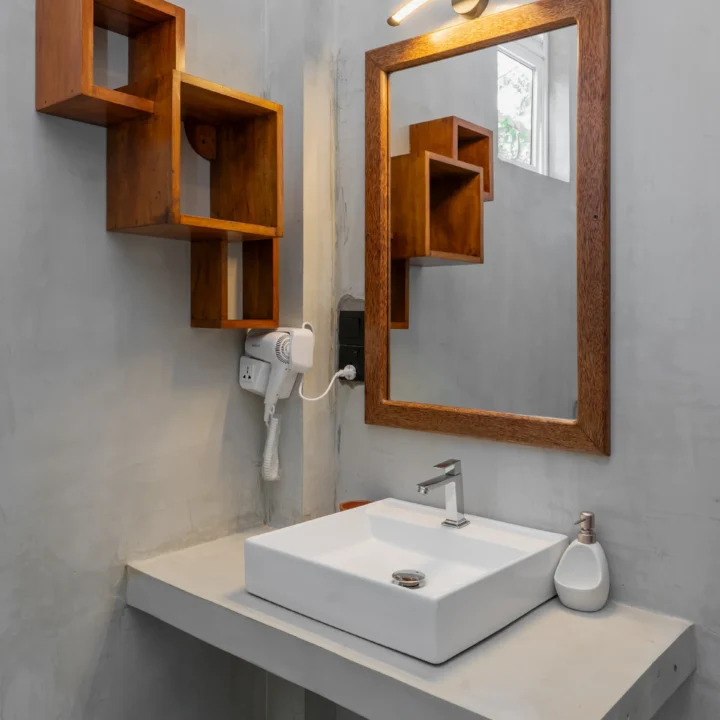Bathroom vanity with wooden mirror frame and stylish wall shelves