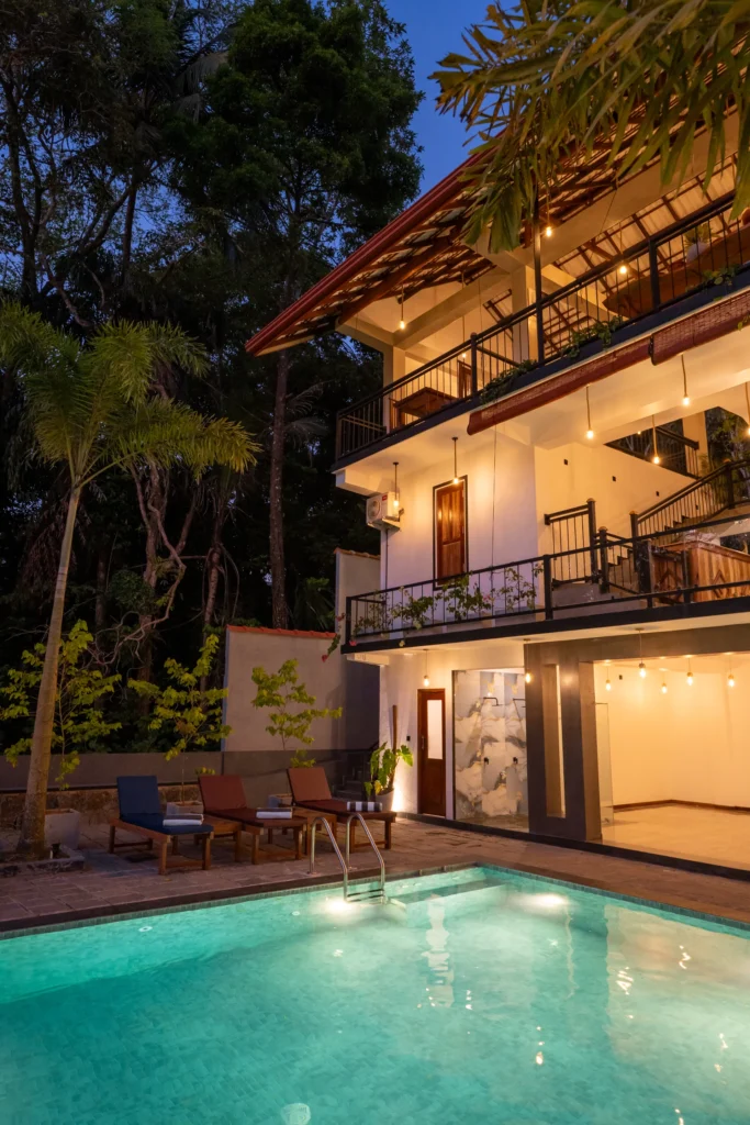 Nighttime poolside view of Arice Eco Villa building and outdoor seating