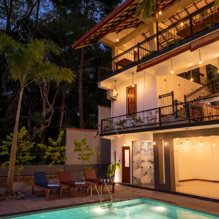 Nighttime poolside view of Arice Eco Villa building and outdoor seating