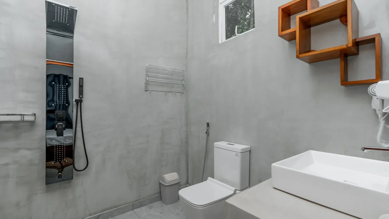 Modern hotel bathroom with rainfall shower panel and minimalist concrete walls